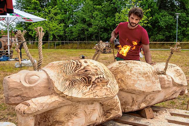 Feurig: Holzbildhauer Joschka Heger gibt seinen Spazander-Käfer-Schildkröten mit dem Brenner den letzten Schliff.