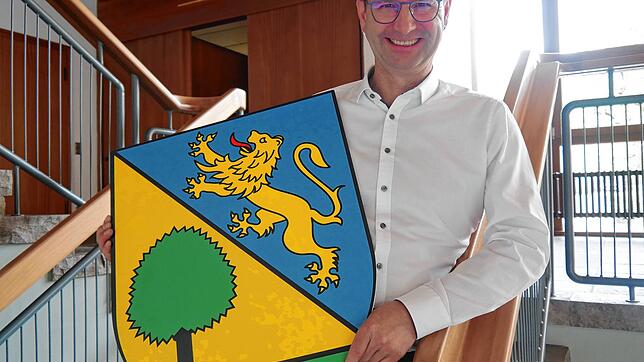 Ein geteiltes Wappen für den ersten gemeinsamen Maibaum: Bürgermeister Patrick Stärk zeigt, was am 30. April am Maibaum hängen soll.