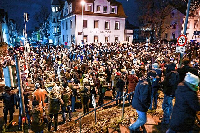 Teilnehmer eines sogenannten Spazierganges gegen die Corona-Maßnahmen gehen durch die Innenstadt von Ravensburg.