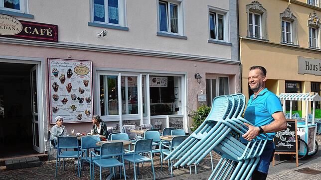 Sommerzeit am Eiscafé: Luca Manarins Arbeitstag beginnt morgens mit dem Tragen der Stühle für die Gäste seiner Eisdiele in der Marktstraße.