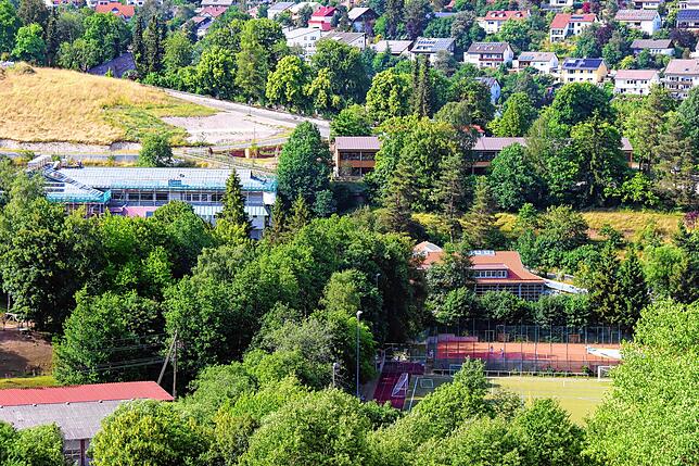 Blick auf Gebäudeensemble Schlossberghalle, Roggenbachschule und Spielscheune Unterkirnach mit Sportanlagen im Vordergrund