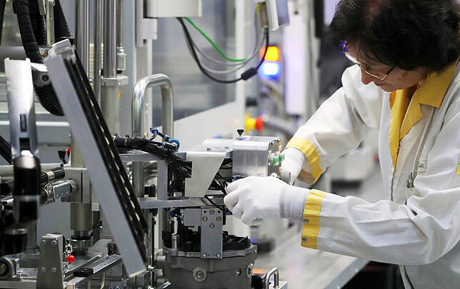 Eine Conti-Mitarbeiterin fertigt im bayerischen Nürnberg einen Elektromotor.