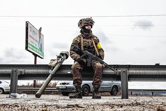 Ein ukrainischer Soldat sitzt am 4. März in Irpin am Straßenrand.