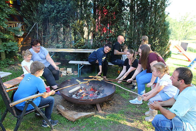 Beim gemeinsamen Grillen am Lagerfeuer kommen die Gäste miteinander ins Gespräch.