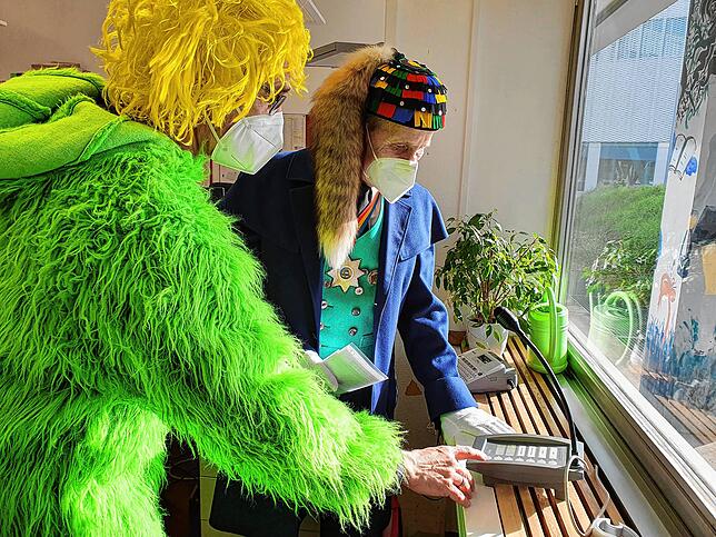 Rektor Hans Weber in Grün öffnet für Frido Mandausch das Mikrophon in alle Klassenräume am Gymnasium.