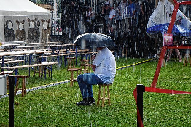 Ein Zuschauer harrt während der Unterbrechung der Aufführung von „Uffrur“ noch lange im Regen aus.