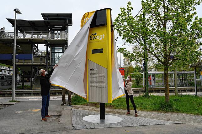 Bürgermeister Karl Langensteiner-Schönborn (von links) und Britta Wittchow (KEA) enthüllen die neue Mobilitätssäule am Bahnhof Fürstenberg.