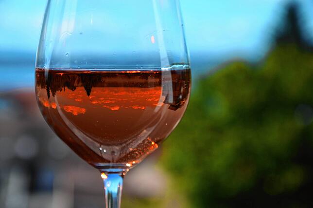 Ein Glas Wein, eingeschenkt mit dem Bodensee in Meersburg im Hintergrund. Die aktuellen Verknappungen und Preissteigerungen betreffen ...