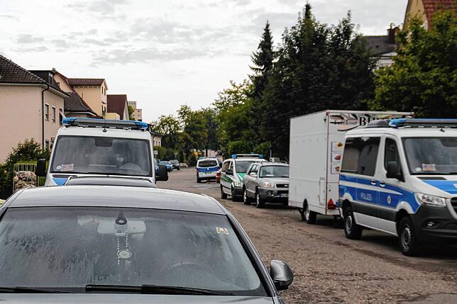 Mindestens zehn Polizeiwagen stehen in den Straßen um das Gebäude. Darunter auch Zivilfahrzeuge der Polizei.