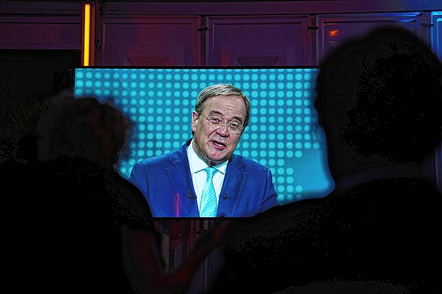 Die Diskussion der Kanzlerkandidaten läuft auf einem Bildschirm in einem VIP Zelt, auf dem Bildschirm Armin Laschet (CDU).