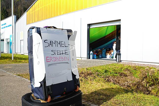Ein unscheinbares Schild vor der Halle weist auf die Sammelstelle hin. Trotzdem verzeichnen die Helfer regen Zulauf.