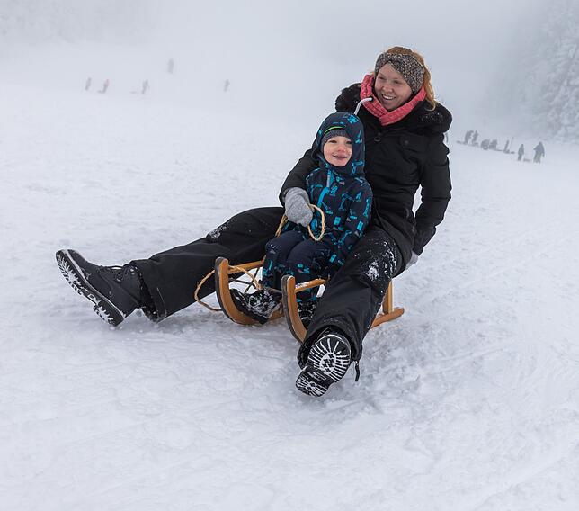 Tanja Gorski und ihr Sohn Julian fahren nahe dem Skilift am Haldenköpfle in Oberried mit ihrem Schlitten den Hang hinunter. Viele ...