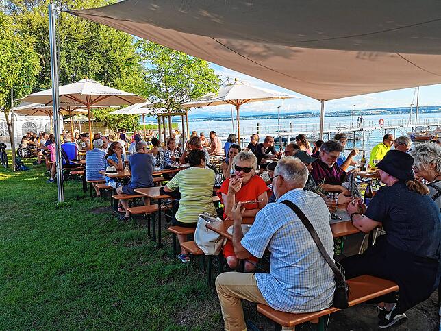 Mit Blick auf den Bodensee machen es sich Besucher im Biergarten des Rebguts Haltnau in Meersburg gemütlich.