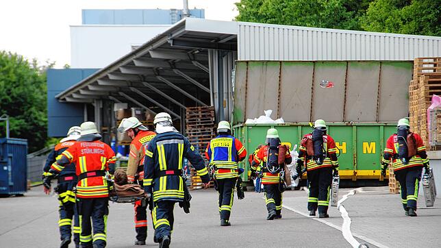 Mitglieder der Feuerwehren bringen Verletzte zu den Betriebs-Sanitätern.