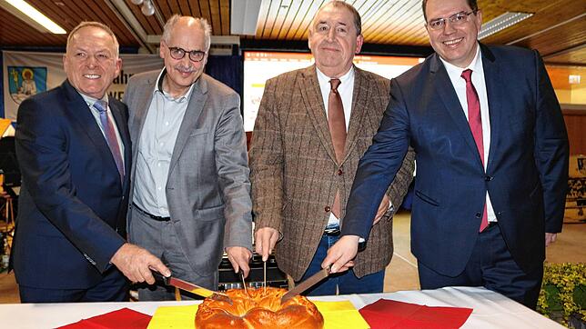 Die Fraktionssprecher des Löffinger Rats und der Bürgermeister schneiden gemeinsam die Neujahrsbrezel an &ndash; als Symbol für die ...