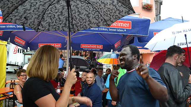 Tanzen unter dem Regenschirm: Die Stimmung bei den Weinfest-Besuchern ist auch bei schlechtem Wetter gut.