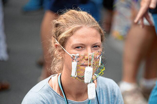 Eine Demonstrantin mit Netz-Maske an der Siegessäule.
