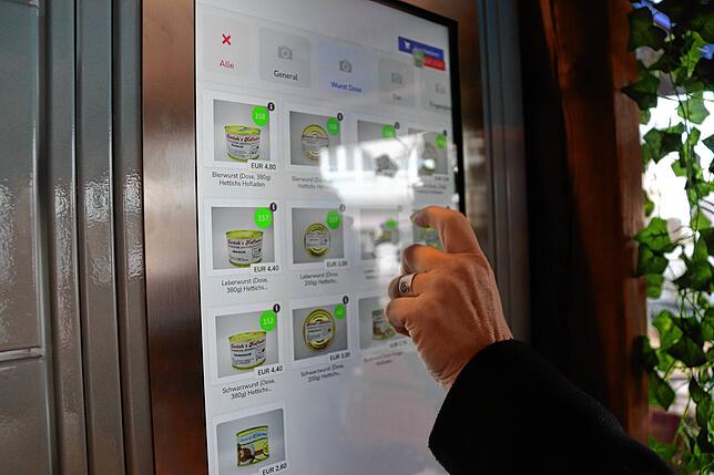 Eine Kundin wählt am Touchscreen aus mehreren Dutzend Optionen aus.