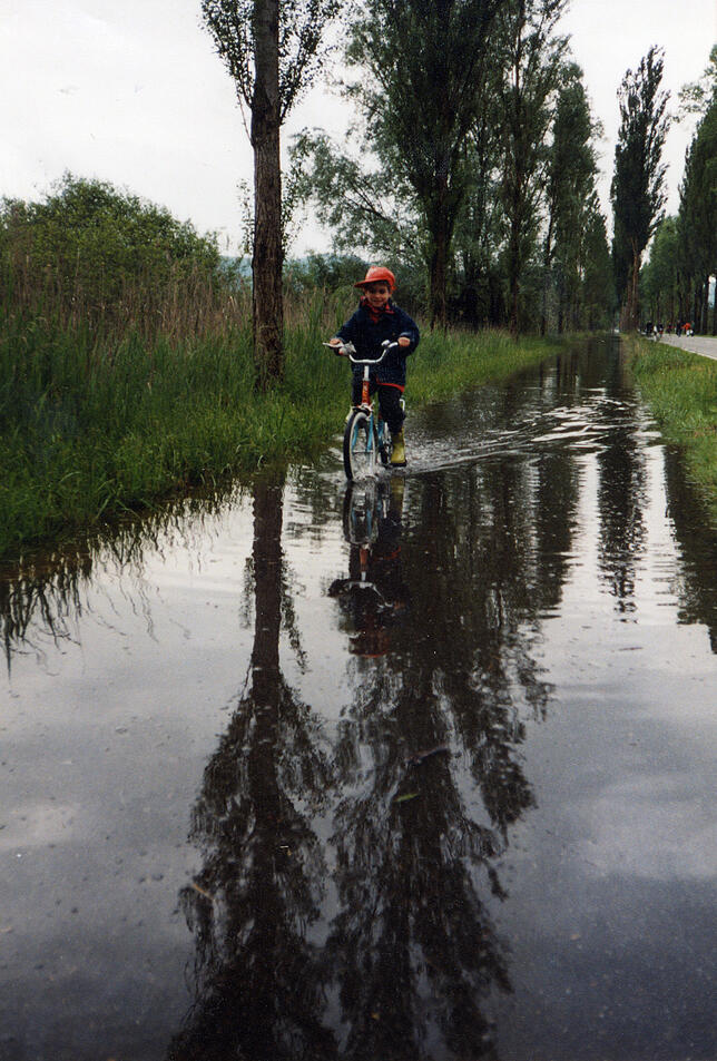 Keine Angst: Der Enkel von Lilo Sillmann kämpft sich mit seinem Rad durchs Wasser auf dem Radweg neben der Landstraße.