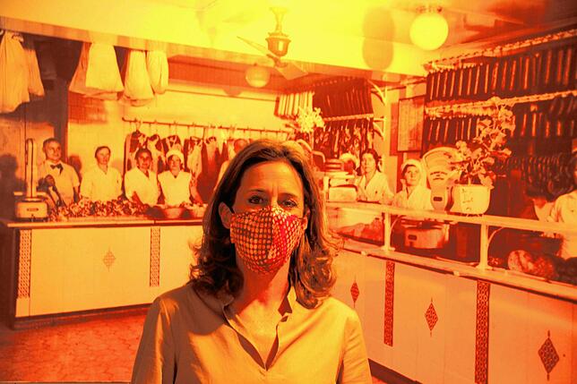 Katharina Müller vor einem historischen Plakat des Familienunternehmens.