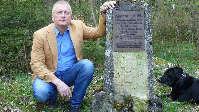 Gerd Stiefel vor dem Gedenkstein, der schon im 19. Jahrhundert in Erinnerung an seinen ermordeten Urahn aufgestellt wurde. Bild: Schöll