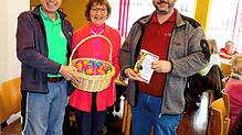 Oliver Neusch (links) und Steffen Pfeiffer übergaben einen Korb mit Ostereiern an Elfriede Müller.