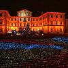 Das Barockschloss wird in wechselndes Licht getaucht. Davor flimmert das Lichtermeer.