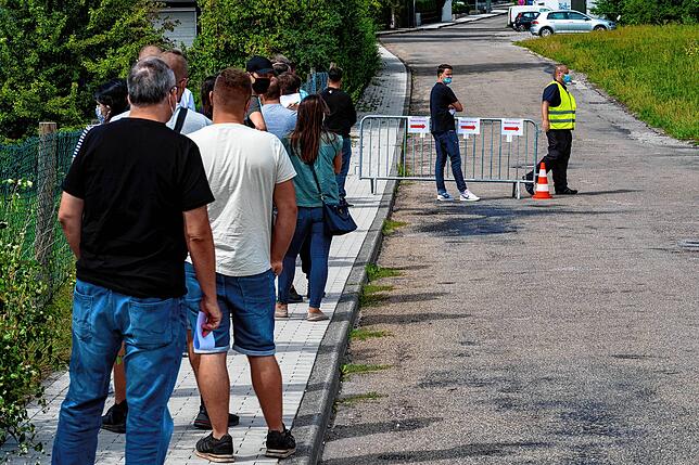 Helfer und Kundschaft stehen auf der Straße.