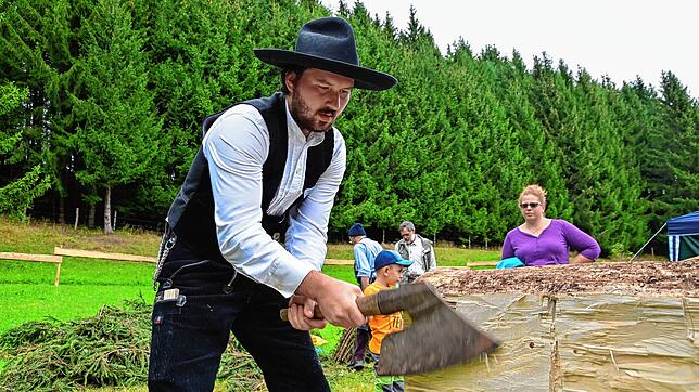 Zimmermann Quirin Säger zeigt am Röthenlochhof am Sonntag, wie man einen runden Baumstamm in einen eckigen Balken verwandelt. „Früher ...