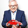 Kommt seinem damaligen Modell laut eigener Aussage sehr nahe: Guido Wolf hält einen roten VW Käfer in Miniaturform in seinen Händen. Die ...