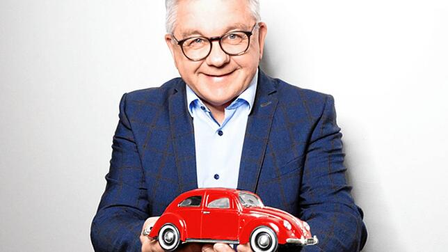 Kommt seinem damaligen Modell laut eigener Aussage sehr nahe: Guido Wolf hält einen roten VW Käfer in Miniaturform in seinen Händen. Die ...