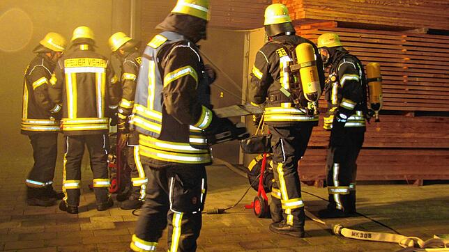 Die Atemschutzträger der Rohrdorfer Feuerwehr machen mit den Entlüftungsgeräten die Lagerhalle wieder rauchfrei. Bild: Karl Mägerle