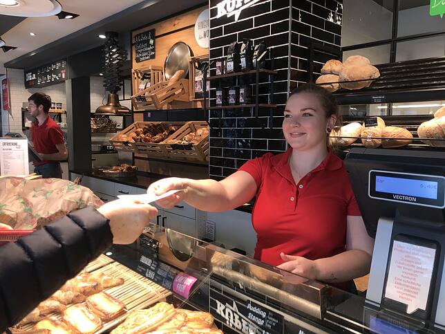 Eine Verkäuferin in der Bäckerei Küpfer in Waldshut gibt einen Kassenbon an einen Kunden.