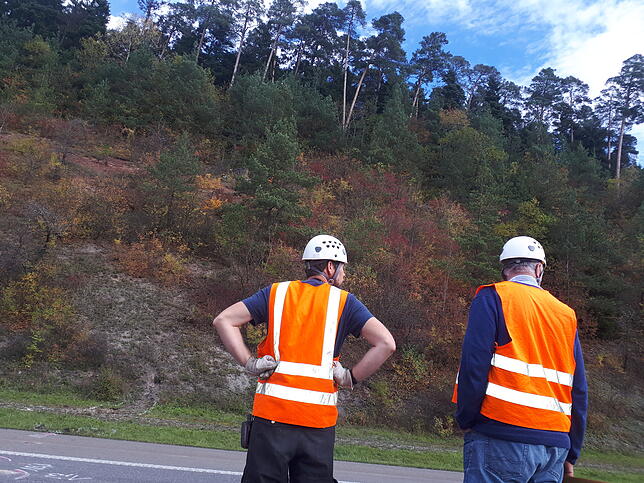 Zwei Geologen des Regierungspräsidiums begutachten die Absturzstelle des Felsbrockens an der Autobahn A81.