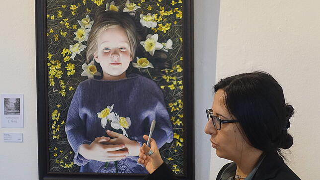 Elena Romanzin erklärt bei der Besichtigung des Grand Salon Colours das Siegerbild Laura von Claudia Kaak.