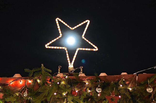 Der fast volle Mond, die Lichter des Weihnachtsmarkt und dahinter der See mit Blick auf die Imperia. Derweil zog ein Boot bei dieser ...