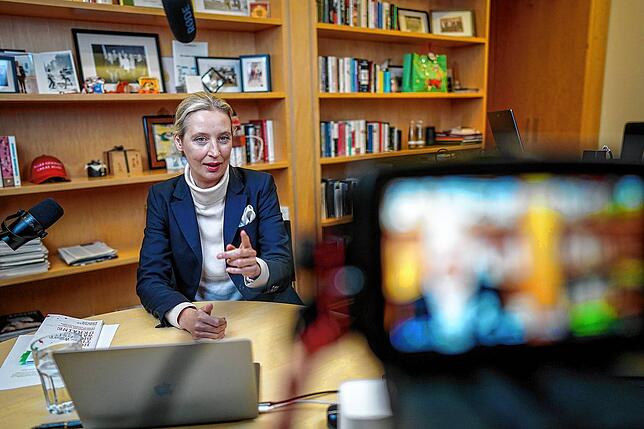 Alice Weidel sitzt vor dem Live-Talk an Mikrofonen und einem Laptop in ihrem Büro des Jakob-Kaiser-Hauses.