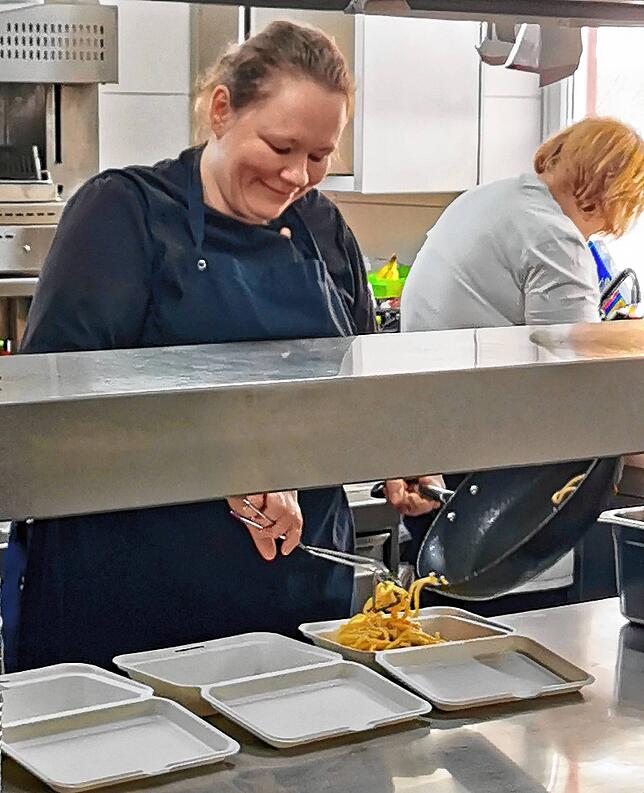 Junior- und Küchenchefin Carina Steimle beim Portionieren von Speisen. Mutter Hannelore Steimle hilft in der Küche bei den Vorbereitungen.