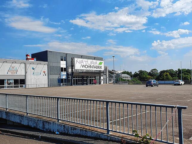 2022: In den früheren Baumarkt ist ein Möbelgeschäft eingezogen. Das zweigeschossige Parkdeck ist unverändert. Im Hintergrund ist der ...
