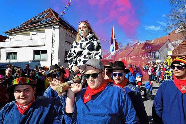 „Nauf auf d‘Stang“. Diese Umzugsbesucherin wird von den jungen Männern der Narrenzunft Nusplingen durch die Hauptstraße getragen.