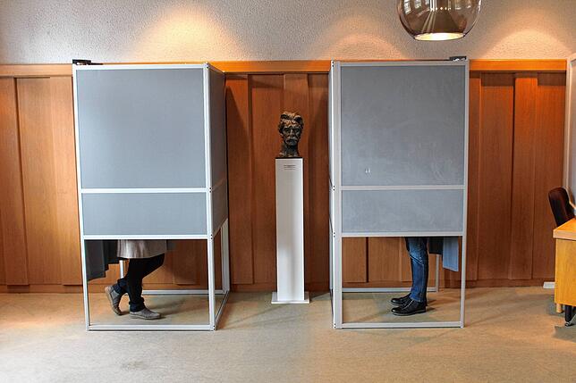 Zwei Wahlberechtigte geben im Sitzungssaal im Königsfelder Rathaus bei der Bürgermeisterwahl ihre Stimme ab.