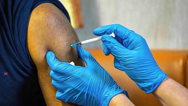 Ein Mann erhält eine Impfung. Gilt die Lohnfortzahlung bei Quarantäne auch ohne Impfschutz? Nein, soll darauf bald die Antwort lauten.