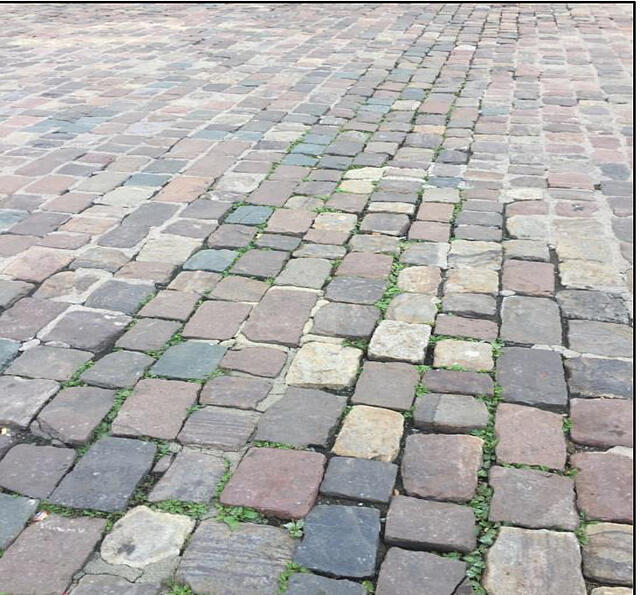 Das ist der Ist-Zustand: Unebene und herausragende Steine und grasbewachsene Fugen.
