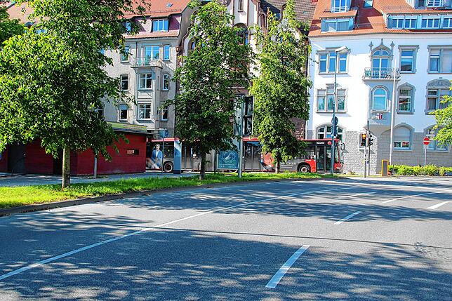 Hinter dem Baum in der Mitte des Bilder steht der Hinweis auf die Abstandsregeln in Konstanz.