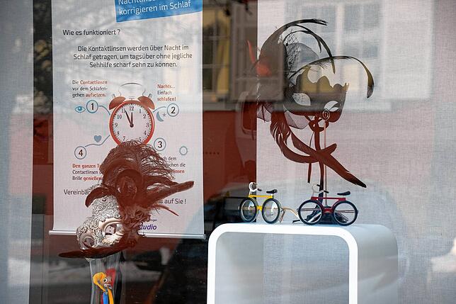 Masken im Brillenstudio-Schaufenster.