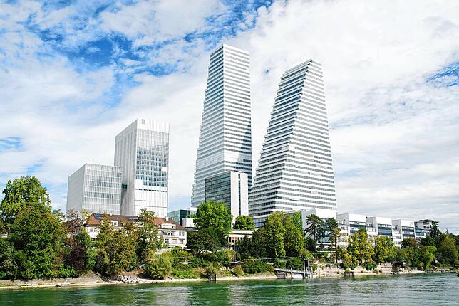 Die beiden Türme des Unternehmens Roche aus einer Perspektive auf dem Wasser des Rheins.