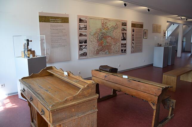 Ein Blick ins Brodmann-Museum im Hohenfelser Rathaus. Vorne sind Möbel aus der ehemaligen Schule zu sehen, an der Wand hängt eine ...