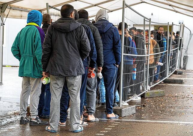 In der Landeserstaufnahmestelle in Ellwangen warten Flüchtlinge in einer Schlange vor der Essensausgabe.