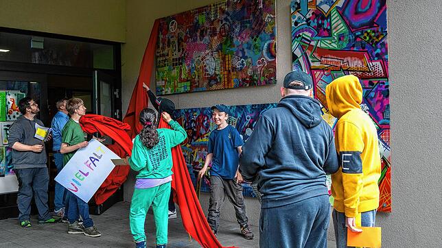 Die junge Künstlergruppe enthüllt ihre großformatigen Werke zum Thema „bunte Vielfalt“ unter dem Applaus von Schülern und Lehrern der ...
