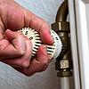 Eine Person dreht am Thermostat einer Heizung in einer Wohnung. Bundeswirtschaftsminister Habeck hat an die Verbraucher appelliert Gas ...